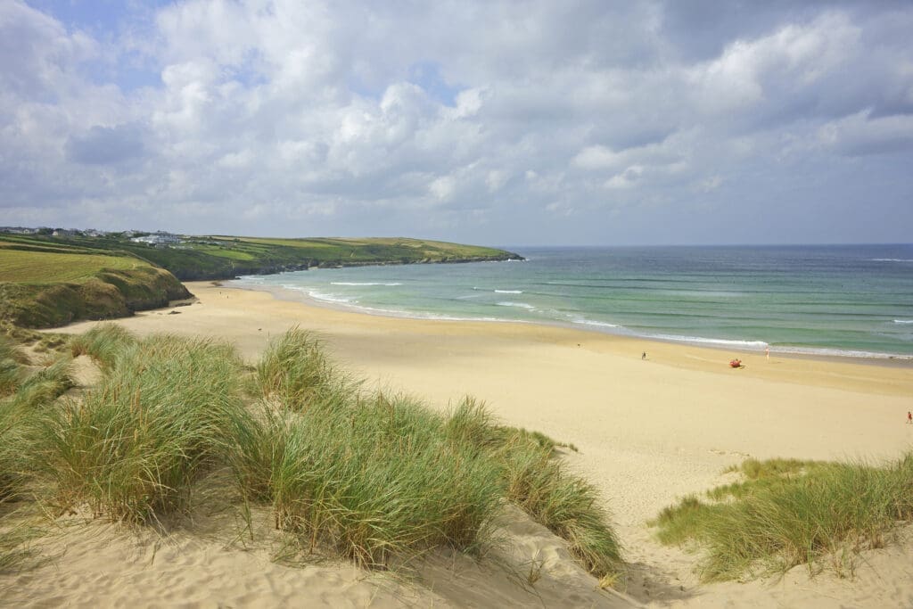 Crantock Bay Beach and Pentire Point showing an incoming tide.